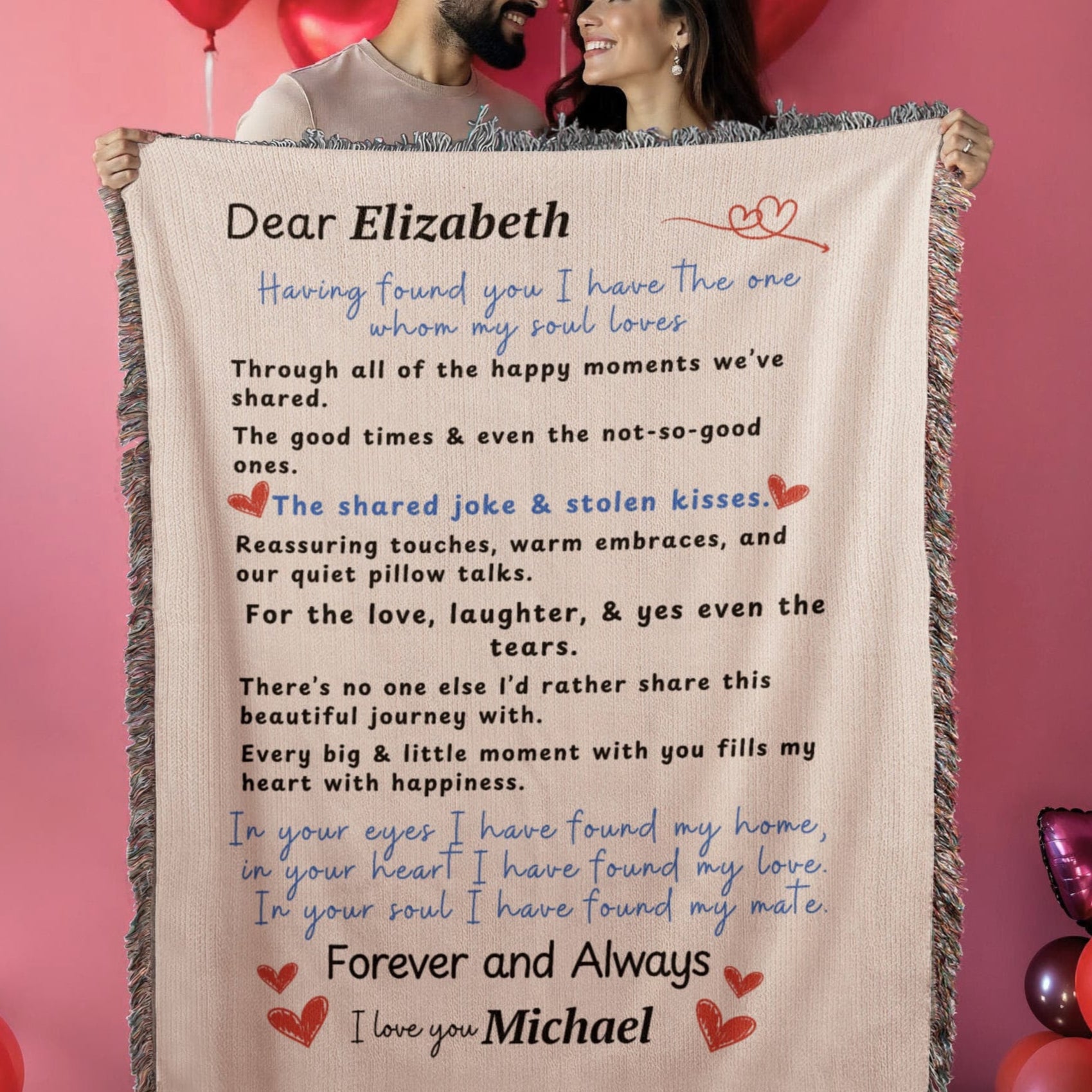 A couple holding A family heirloom blanket it is a love letter.  A Personalize Gift with custom names. A couple is hold the blanket up in a Valentine's theme background. 